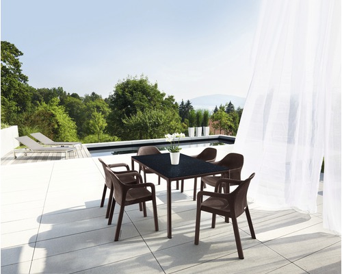 Trädgårdsmöbelgrupp med bord och stolar på en terrass med utsikt över poolen