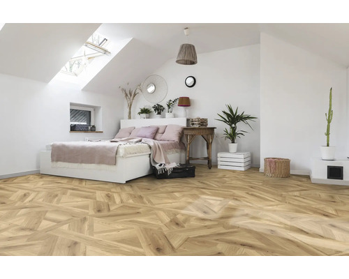 Sovrum med takfönster, säng och trägolv i fiskbensmönster