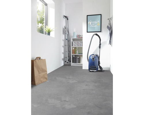 Ljust rum med stege, hylla, dammsugare och grått golv