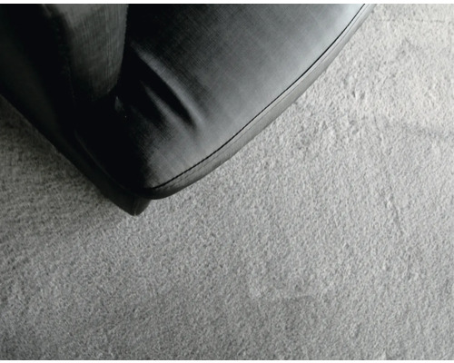 Närbild av en grå matta bredvid en möbel