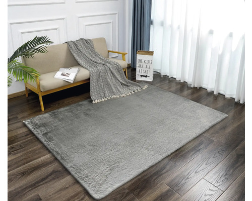 Vardagsrum med grå matta, soffa och gardiner