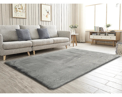 Vardagsrum med grå matta, soffa, bord och byrå