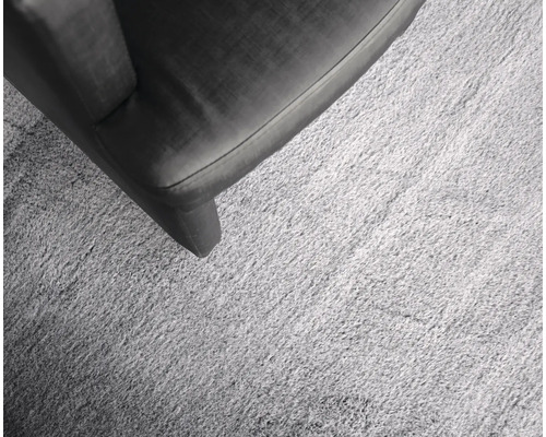 Detaljvy av en ljusfärgad matta bredvid en möbel