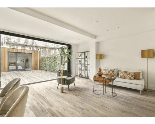 Ljust vardagsrum med altandörr, soffa och hyllor