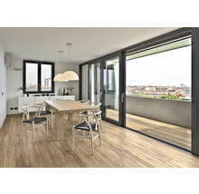 Ljus matplats med trägolv, matbord och skjutdörr till balkong med utsikt över staden