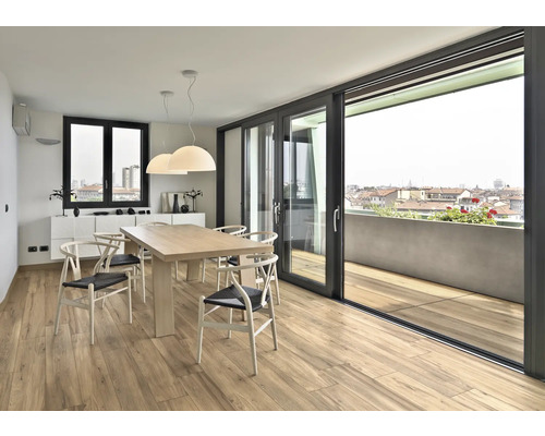 Ljus matplats med trägolv, matbord och skjutdörr till balkong med utsikt över staden
