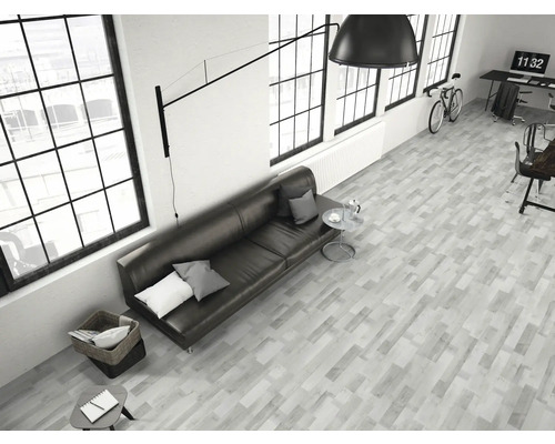 Ljust vardagsrum med soffa, bord, stol och parkettgolv