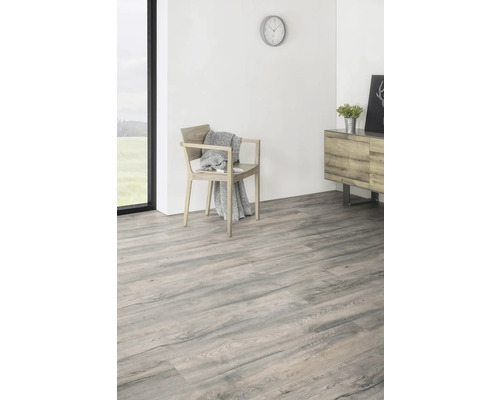 Ljust rum med laminatgolv i trälook, stol och byrå