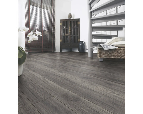 Interiör med laminatgolv, byrå och spiraltrappa