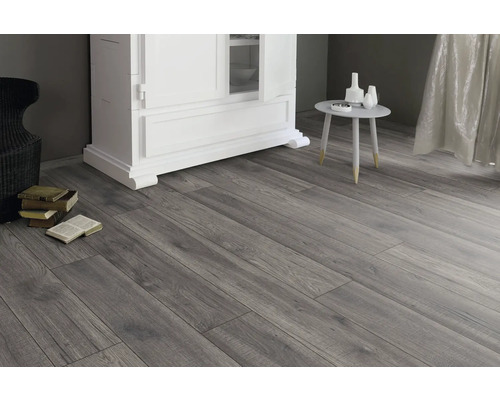 Interiör med laminatgolv i träutseende, byrå, bord och dekoration