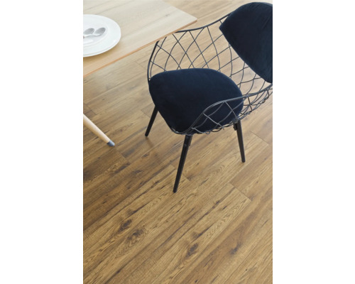 Interiörbild av ett rum med trägolv, stol och bord