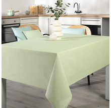 Dukat matbord med ljusgrön duk i ett modernt kök.