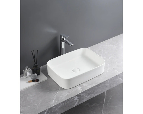 Rektangulärt tvättställ i keramik med blandare på en marmorskiva