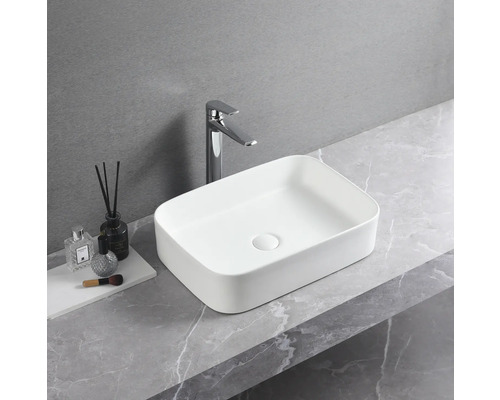 Rektangulärt tvättställ i keramik med blandare på en bänkskiva