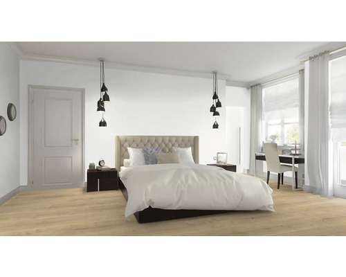 Ljust sovrum med säng, sängbord, taklampor och skrivbord vid fönstret.