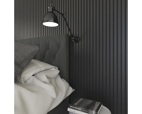 Sovrum med väggpaneler, säng, sänglampa och bok