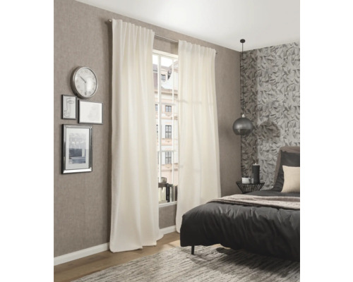 Sovrum med säng, matta, klocka och vita gardiner