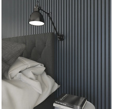 Sovrum med väggpaneler, sänglampa och säng