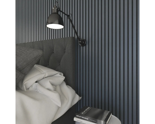 Sovrum med väggpaneler, sänglampa och säng