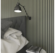 Sovrumsvägg med träpaneler, sänggavel och justerbar vägglampa.