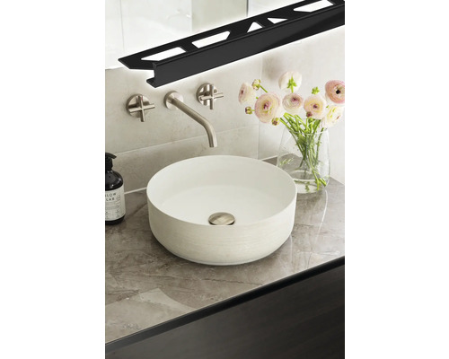 Modernt badrum med tvättställsskål, blandare, blommor och LED-profil