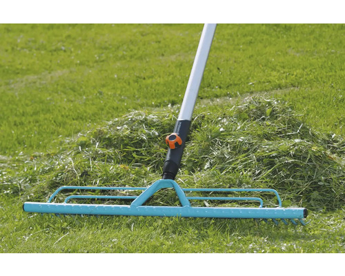 Trädgårdsräfsa för att samla ihop gräsklipp på gräsmattan