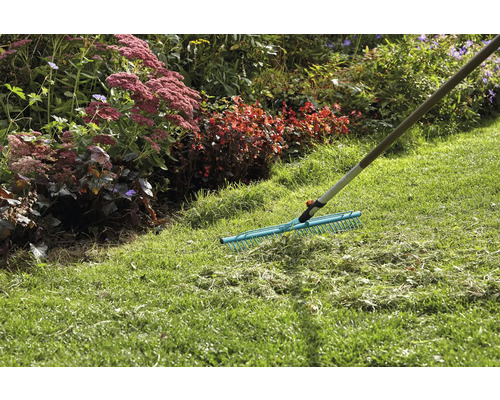 Trädgårdsräfsa för att ta bort gräsklipp på gräsmattan