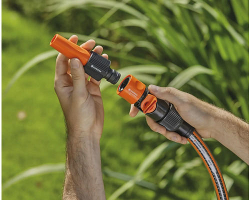 Trädgårdsslangskoppling hålls av händer