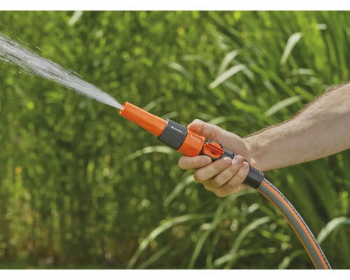 En hand håller en trädgårdsdusch som sprutar vatten.