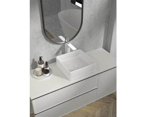 Modernt badrum med tvättställsskåp, handfat, spegel och badrumstillbehör