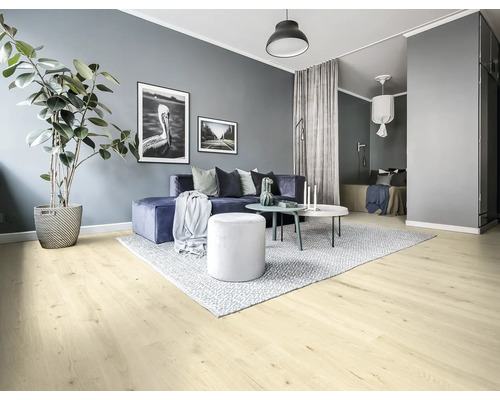 Ljust vardagsrum med soffa, matta, bord och krukväxt på ljust trägolv