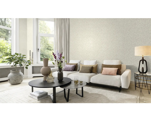 Vardagsrum med soffa, soffbord och tapet med bladmönster