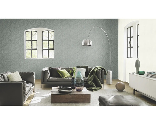 Vardagsrum med grå non-woven tapet, lädersoffor, träbord och golvlampa