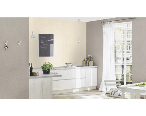 Ljust köksutrymme med vita skåp, matbord och griffeltavla