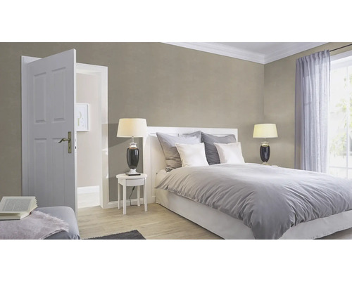 Sovrum med säng, sängbord, lampa, gardiner och öppen dörr