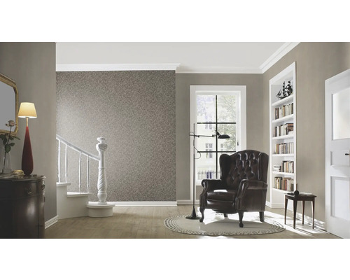 Vardagsrum med tapet, fåtölj, trappa och dekorativa element för en mysig atmosfär