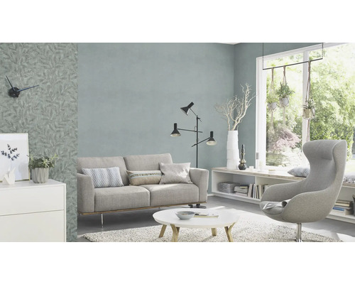 Vardagsrum med soffa, fåtölj, golvlampa och mönstrad tapet