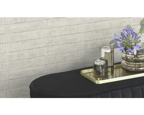 Väggplattor med stenutseende som bakgrund för en dekoration på en konsol.