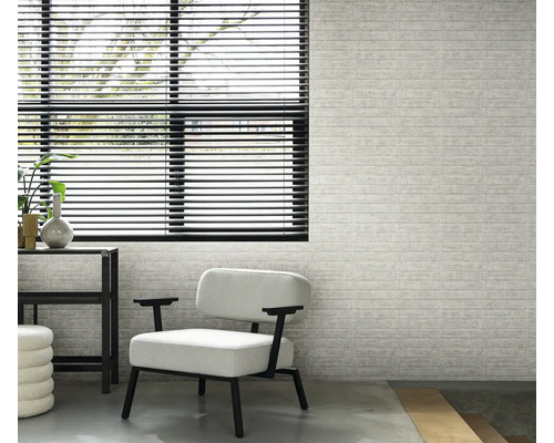 Interiör med fönster, persienner, fåtölj och en vägg med tegelmönster