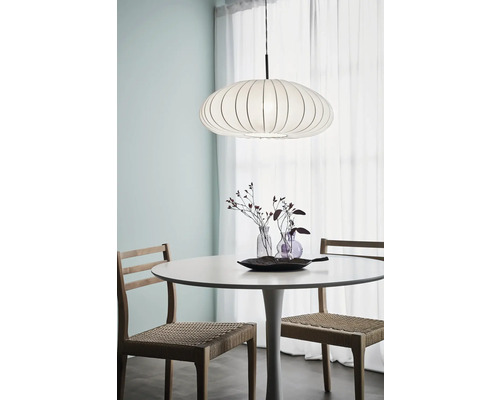 Matsal med matbord, stolar och en hängande lampa.