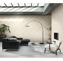 Vardagsrum med svart lädersoffa, fåtölj, krukväxter och tapeter i fiskbensmönster