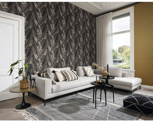Vardagsrum med grå soffa, mönstrad matta och bladtapet för en mysig atmosfär