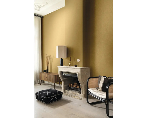 Vardagsrum med mönstrad tapet, öppen spis och sittplatser