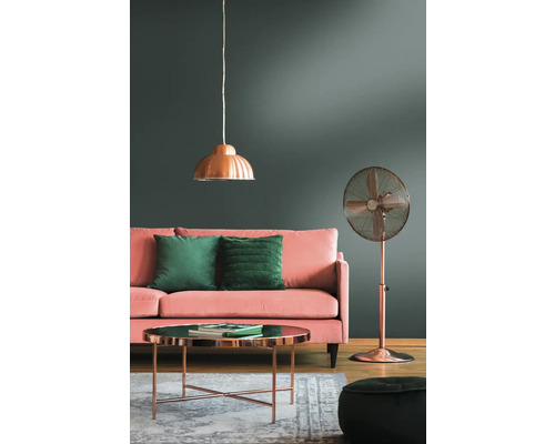 Vardagsrum med soffa, kuddar, bord, golvfläkt och taklampa