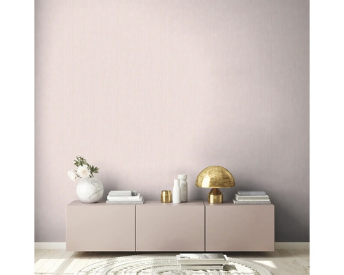 Scen med en låg skänk mot en vägg med vertikalrandig tapet.