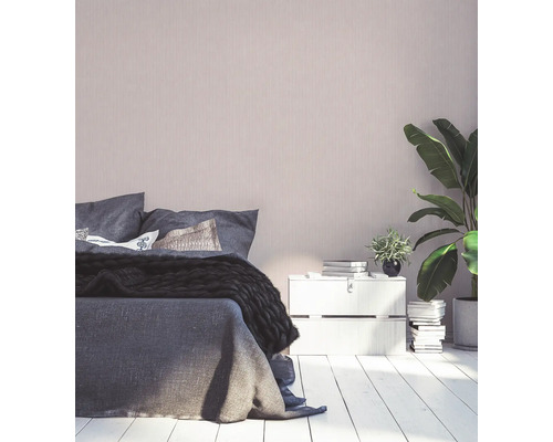 Sovrum med säng, sängbord, krukväxter och dekorativ väggbeklädnad för en mysig atmosfär