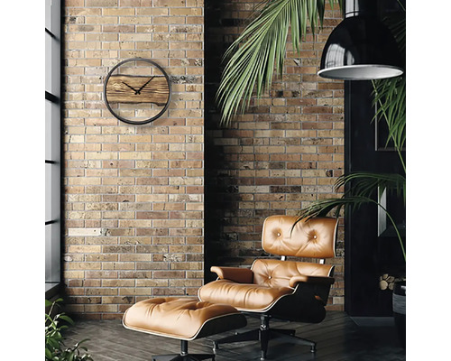 Vardagsrum med tegelvägg, fåtölj och väggklocka