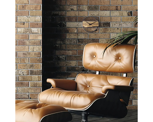 Rumsvy med läderfåtölj, fotpall och väggklocka mot en tegelvägg.