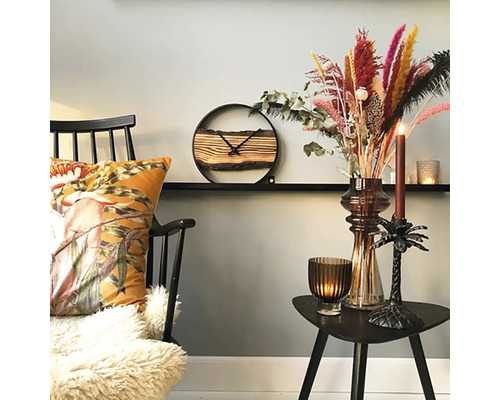 Dekorativt boende med stol, kudde, klocka, torkade blommor och ljus