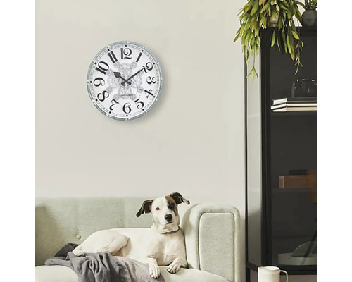 Vardagsrum med väggklocka och hund i soffan